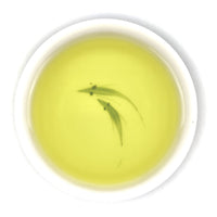 Hellgelb-grüner, klarer Aufguss des High-End Wenshan Baozhong Oolong Tees in einer traditionellen Gaiwan.